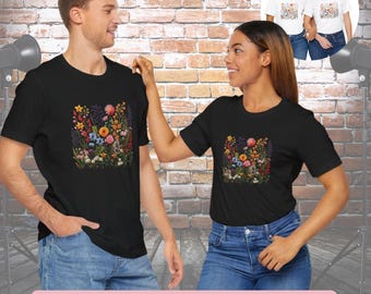 May include: Two people wearing black t-shirts with embroidered wildflowers. The shirts have a black background and feature a colorful floral design. The text "Embroidery Look Wildflower Tshirts" is at the bottom of the image.