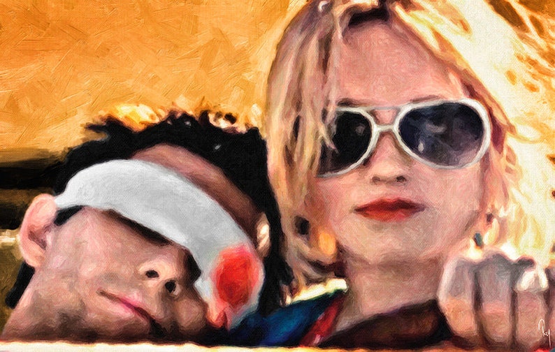 K&ouml;nnte beinhalten: Eine Frau mit blonden Haaren, die eine Sonnenbrille tr&auml;gt, schaut in die Kamera, w&auml;hrend ein Mann mit einem wei&szlig;en Verband &uuml;ber den Augen schl&auml;ft. Die Frau tr&auml;gt ein blaues und rotes Hemd.