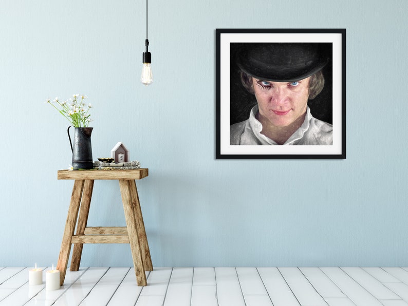 K&ouml;nnte beinhalten: Ein gerahmtes Schwarzwei&szlig;portr&auml;t einer Person, die einen schwarzen Bowlerhut und ein wei&szlig;es Hemd tr&auml;gt. Die Person hat dunkles Haar und blaue Augen. Der Hintergrund ist schwarz.