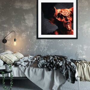 May include: A framed painting of a red demon with horns and glowing yellow eyes. The demon is looking directly at the viewer with a serious expression.