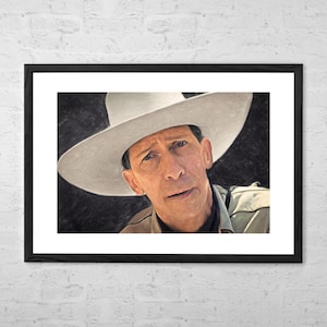 Op de afbeelding: Een close-up portret van een man met een witte cowboyhoed. Hij heeft een serieuze uitdrukking op zijn gezicht en kijkt rechtstreeks naar de kijker. De achtergrond is donker en wazig.