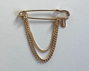 Golden safety pin chain statement brooch