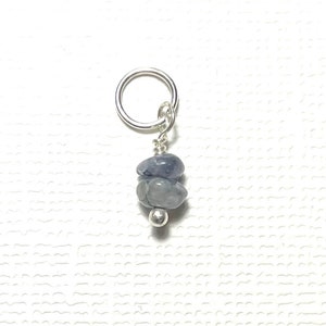 May include: A silver-toned earring charm featuring three blue-gray stones and a small silver bead. The charm is suspended from a silver ring. The stones are stacked, with the bead at the bottom.