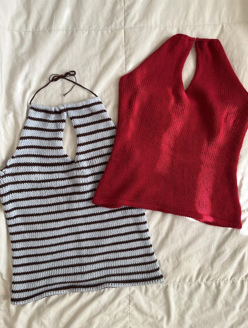 May include: Two knitted halter tops. One is light blue with horizontal brown stripes. The other is solid red. Both tops have a keyhole neckline and are made of a soft, textured material. The tops are displayed on a white surface.