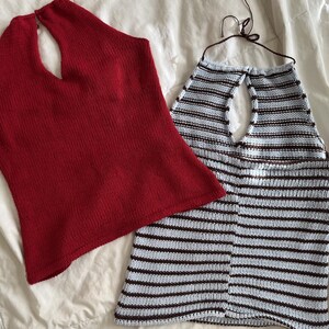 May include: Two knitted halter tops. One is solid red, the other is light blue with brown horizontal stripes. Both tops have a keyhole neckline and are made of a soft, textured knit fabric. The tops are displayed on a white surface.