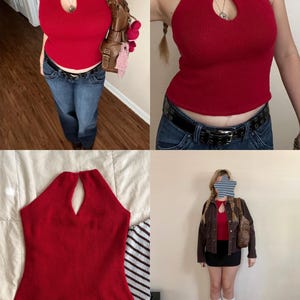 May include: A red halter top with a keyhole neckline. The top is ribbed and appears to be made of a knit material. The top is paired with blue jeans and a black belt. A brown leather bag is also visible.