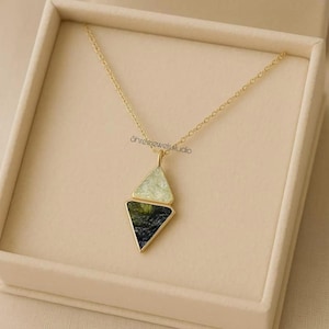 May include: A gold-colored necklace with a pendant featuring two stacked, diamond-shaped stones. The top stone is light green, and the bottom stone is dark green and black. The necklace is displayed in a beige box, with the text "Shreejewelsstudio".
