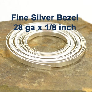 May include: A coil of silver bezel wire, 28 gauge and 1/8 inch wide, for jewelry making.