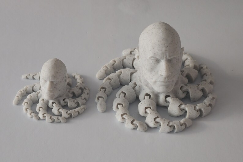May include: Two 3D printed sculptures of a human head with a textured surface, each with a set of tentacles surrounding the head.