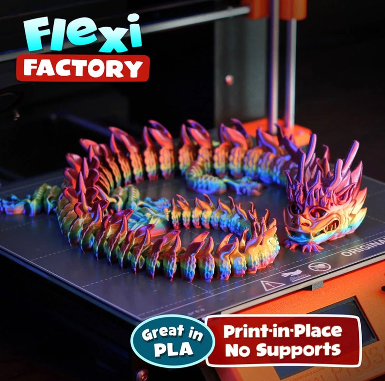 May include: A 3D printed dragon model in a rainbow iridescent color. The dragon is curled up on a black print bed. The text "Flexi FACTORY" is visible in the background. The text "Great in PLA" and "Print-in-Place No Supports" is visible in the foreground.