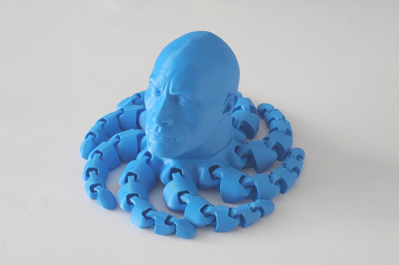 May include: A 3D printed blue sculpture of a person's head with a blue octopus-like body made of linked segments.
