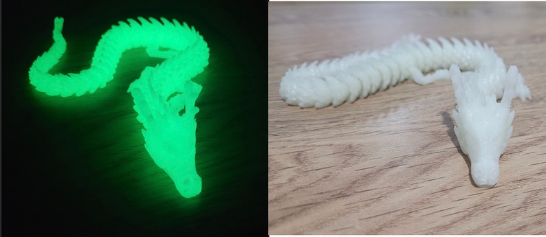 May include: A white plastic dragon figurine with a glow-in-the-dark feature. The dragon is curled up in a resting position with its head resting on its body. The dragon is shown in two images, one in a dark environment where the glow-in-the-dark feature is visible, and the other in a well-lit environment.