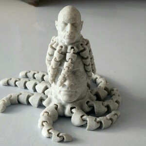 May include: A white 3D printed sculpture of a human head with multiple tentacles extending from the neck. The head has a serious expression and the tentacles are made of interlocking segments.