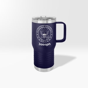 May include: A navy blue stainless steel travel mug with a white United States Navy seal and the name "Joseph" engraved on the front.
