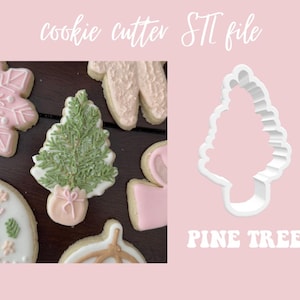 Puede incluir: Un cortador de galletas de plástico blanco con forma de árbol de pino. El cortador se muestra junto a varias galletas decoradas, incluyendo un copo de nieve, un árbol de pino y una corona. El texto "PINE TREE" está impreso debajo del cortador.