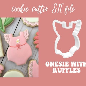 May include: A pink onesie cookie cutter with ruffles, next to a decorated cookie. The cookie is pink with a daisy and bow detail. The text "cookie cutter STL file" is at the top, and "ONESIE WITH RUFFLES" is at the bottom.