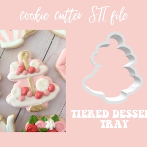 Pode incluir: Um cortador de biscoitos branco em forma de bandeja de sobremesa de vários níveis. O cortador é mostrado em um fundo rosa com o texto "TIRED DESSERT TRAY" em letras brancas.