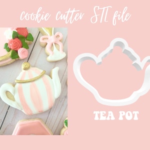 May include: A white plastic cookie cutter shaped like a teapot. The cutter is on a pink background with the words "TEA POT" printed below it.