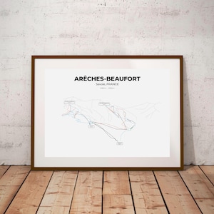 Op de afbeelding: Een zwart-witte ski-kaartprint van het skigebied Arêches-Beaufort in Savoie, Frankrijk. De print toont de skipistes en liften van het skigebied. De print is ingelijst in een bruin frame.