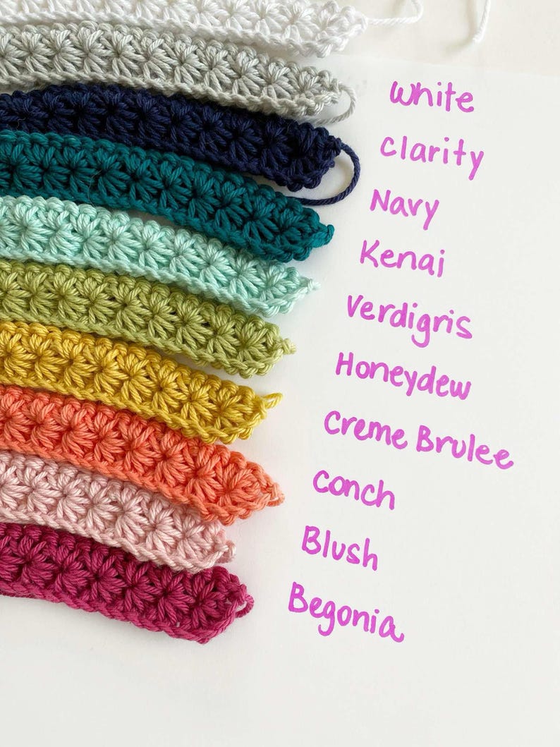 May include: A collection of crochet yarn samples in various colors, including white, navy, teal, green, yellow, orange, pink, and red. The colors are labeled with names like "Clarity", "Kena" and "Begonia".