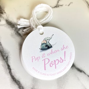 May include: A white round tag with a pink elephant illustration and the text 'Pop it when she Pops! Raise a glass & toast when baby Olivia arrives'.
Pop It When She Pops Personalized Baby Shower Mini Champagne Bottle Favor Tag Prosecco Elephant Gift Tag Custom Baby Shower Gift Tag