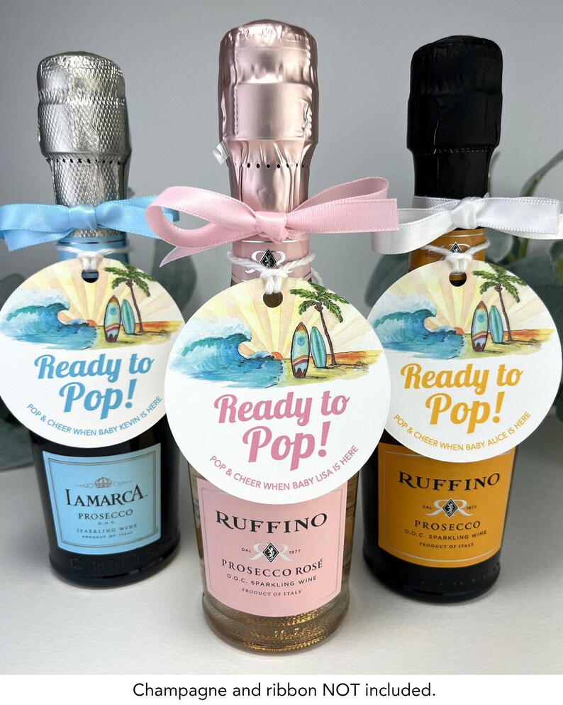 Może przedstawiać: Trzy mini butelki wina musującego z personalizowanymi etykietami, na kt&oacute;rych widnieje napis "Ready to Pop!" wraz ze sceną plażową i tekstem "Pop & Cheer When Baby [Name] Is Here".