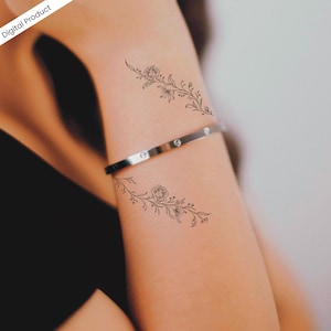K&ouml;nnte beinhalten: Ein digitales Produkt mit zwei floralen tempor&auml;ren Tattoos. Die Tattoos sind schwarze Strichzeichnungen von Rosen und Bl&auml;ttern, die auf dem Arm platziert sind. Ein silbernes Armband ist ebenfalls sichtbar. Die Worte "Digital Product" befinden sich in der oberen linken Ecke.