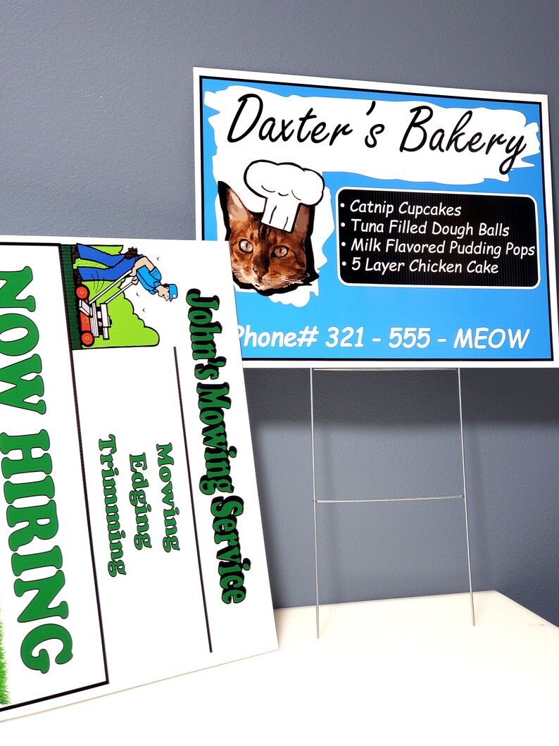 May include: Two signs: "Daxter's Bakery" with a cat wearing a chef's hat and a list of cat treats, and "John's Mowing Service" with a lawnmower graphic and "Now Hiring". The bakery sign has a blue background and the phone number 321-555-MEOW.