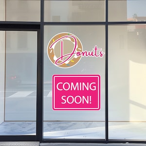May include: A storefront window with a pink sign that says "Coming Soon!" and a donut graphic with the text "Donuts" in pink.