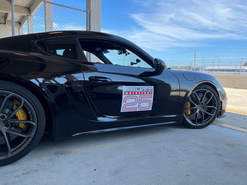 May include: Black Porsche sports car with a Pruitt Motorsport sticker and the number 25 on the side.