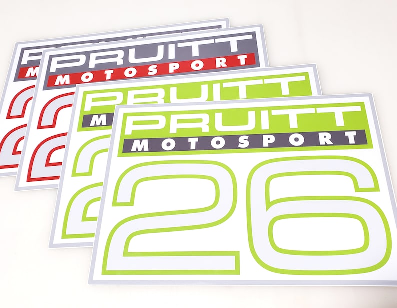 Pu&ograve; includere: Quattro adesivi bianchi con il testo "Pruitt Motorsport" in lettere nere e verdi. L'adesivo pi&ugrave; grande ha il numero "26" in verde con un contorno bianco.