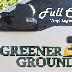 Pu&ograve; includere: Un camion bianco con un logo in vinile verde e nero che dice "Greener Grounds" con un sole giallo e palme. Il testo "Full Color Vinyl Logos & Decals" &egrave; anche sul camion.