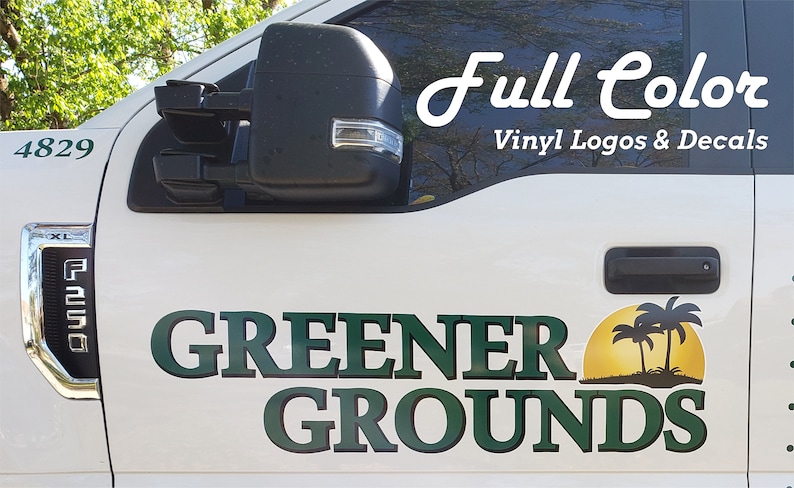 Pu&ograve; includere: Un camion bianco con un logo in vinile verde e nero che dice "Greener Grounds" con un sole giallo e palme. Il testo "Full Color Vinyl Logos & Decals" &egrave; anche sul camion.