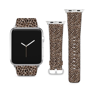 Könnte beinhalten: Eine silberne Apple Watch mit einem braunen und schwarzen Leopardenmusterband. Das Zifferblatt der Uhr ist schwarz mit weißen Zeigern.