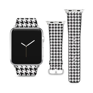 May include: A black and white houndstooth patterned watch band for an Apple Watch. The band is shown on a silver Apple Watch with a black face.