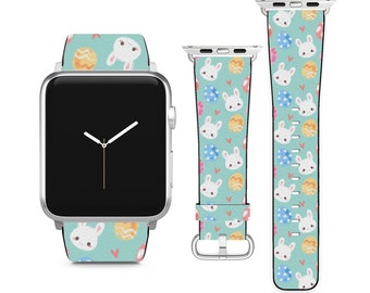 May include: A white Apple Watch with a light blue and white patterned band featuring bunnies and Easter eggs. The band is made of silicone and has a silver buckle.
