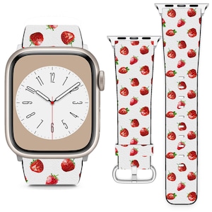 May include: A white Apple Watch band with a red strawberry pattern. The band is shown on a gold Apple Watch with a white face.