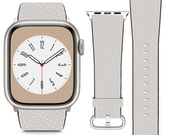 Könnte beinhalten: Ein weißes Apple Watch Armband mit einem dezenten Punktmuster. Das Armband ist auf einer goldenen Apple Watch mit weißem Zifferblatt zu sehen.