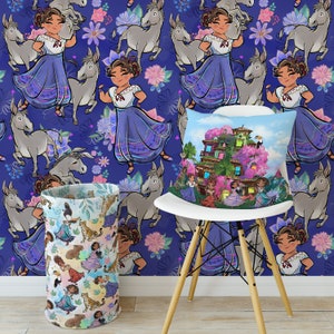 May include: A white chair with a blue and purple patterned throw pillow featuring a cartoon illustration of a house with pink flowers. The chair is in front of a wall with a repeating pattern of cartoon donkeys and girls in blue dresses.