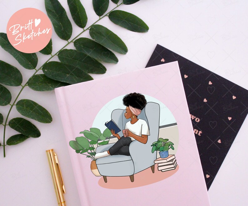 May include: A pink journal with an illustration of a person reading in a chair. The illustration includes a person with dark hair, a white shirt, and black pants. The journal has the text "two" and "ent" on the cover.