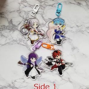 May include: Four colourful anime character keychains with different designs. Each keychain features a character with a unique outfit and accessories. The keychains are made of clear acrylic and have a metal ring for attaching to keys or bags.