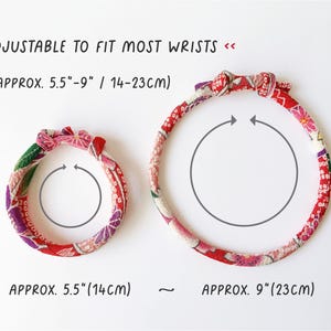 May include: Two fabric bracelets with floral patterns in red, pink, and green. The text says "ADJUSTABLE TO FIT MOST WRISTS" and the bracelets are approximately 5.5" (14cm) and 9" (23cm) in diameter.