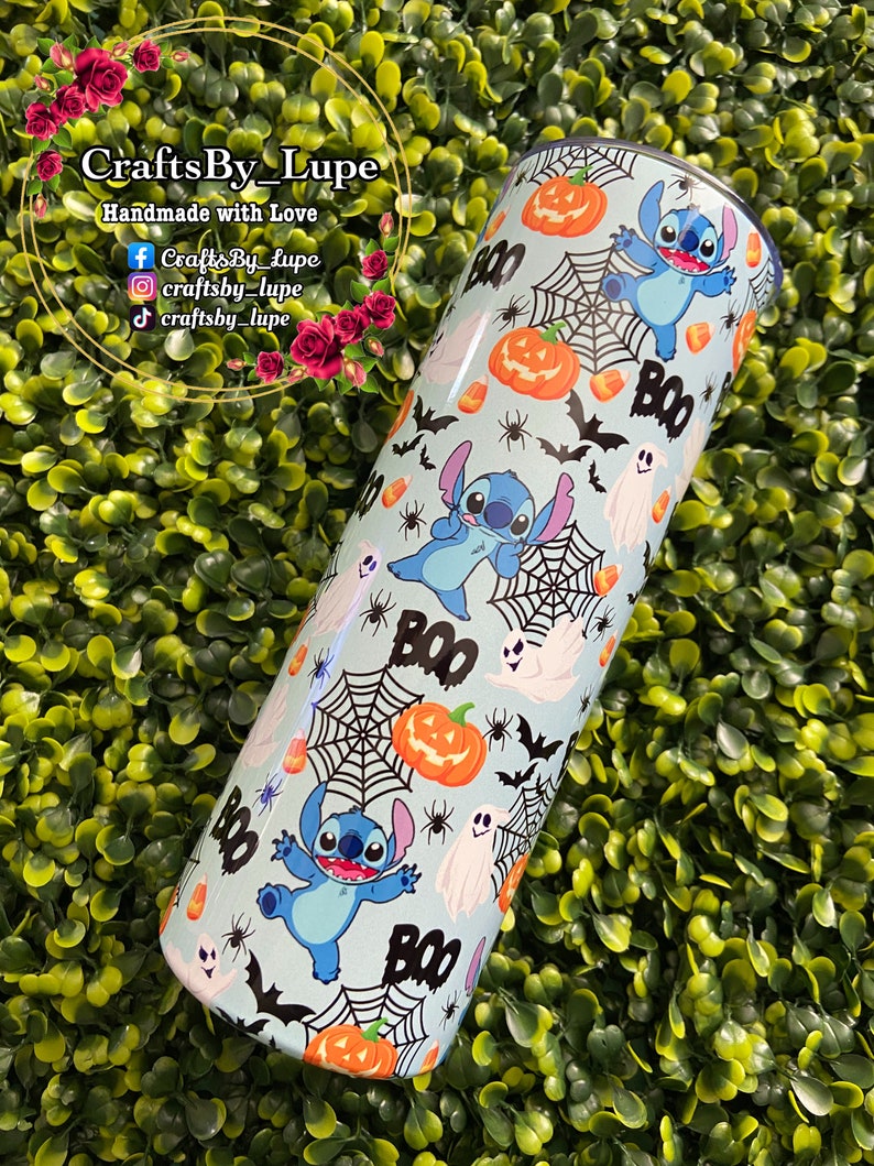 K&ouml;nnte beinhalten: Ein blauer und wei&szlig;er Edelstahlbecher mit Halloween-Motiv. Der Becher zeigt ein sich wiederholendes Muster von Stitch aus Lilo & Stitch, K&uuml;rbissen, Geistern, Flederm&auml;usen, Mais und Spinnweben. Der Text "BOO" erscheint mehrmals auf dem Becher.