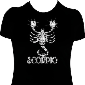 May include: Black t-shirt with a rhinestone scorpion design and the word "SCORPIO" in rhinestones.