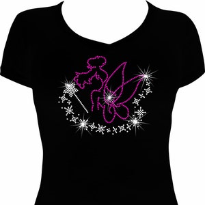 May include: A black t-shirt with a pink rhinestone design of a fairy with wings and a wand surrounded by white rhinestones.
