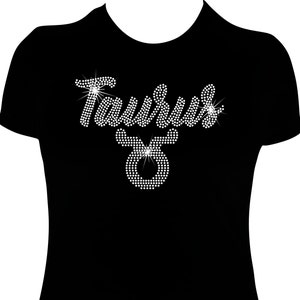 May include: Black t-shirt with a rhinestone design of the word "Taurus" and the Taurus zodiac symbol.