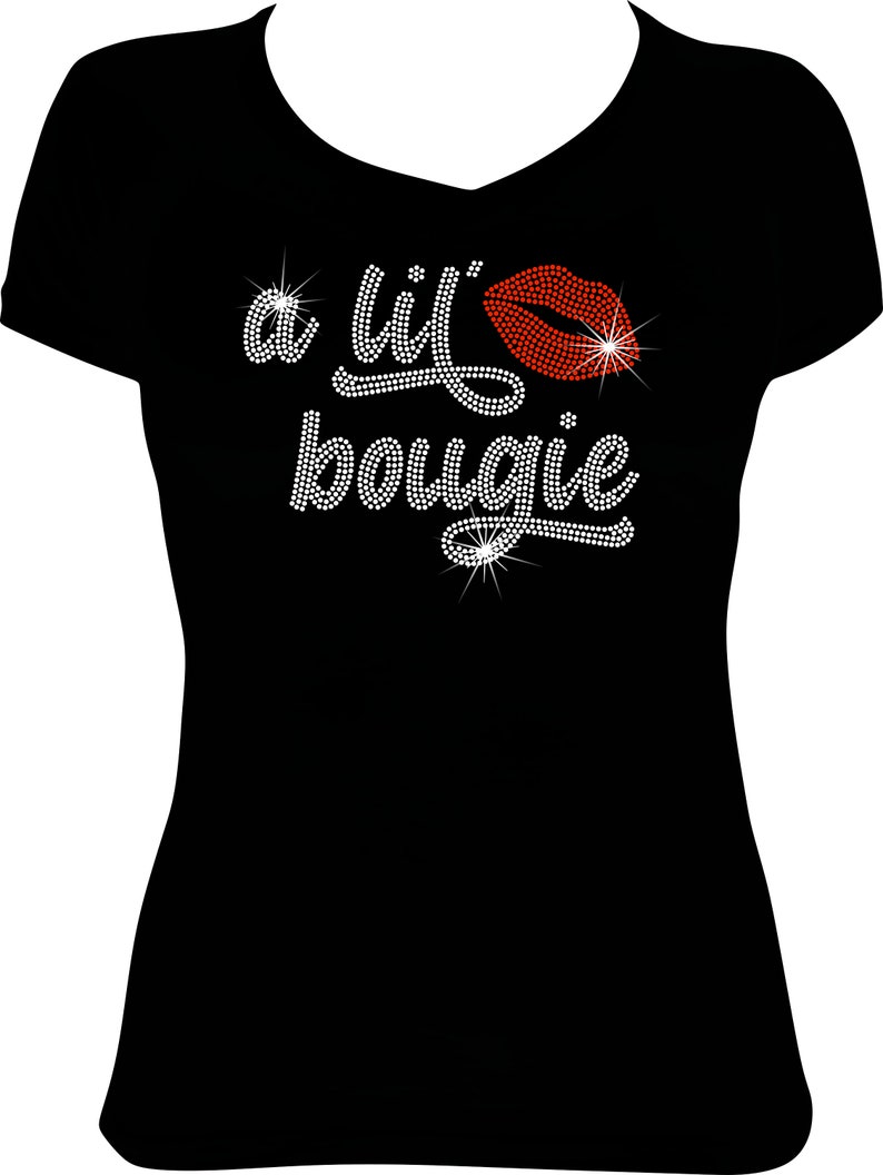 May include: A black short-sleeved t-shirt with a V-neckline featuring a rhinestone graphic on the chest. The design consists of the text 'a lil' bougie' in white rhinestones and a red rhinestone lip icon, creating a sparkling, textured effect.