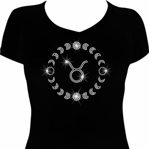 May include: Black v-neck t-shirt featuring a white rhinestone design of the Taurus zodiac symbol. The design includes the Taurus symbol, surrounded by a circle of moon phases and starbursts.