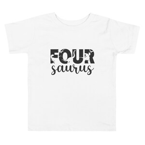 May include: White toddler t-shirt with the text "FOUR saurus" in black. The word "FOUR" has dinosaur silhouettes inside the letters. The word "saurus" is in a cursive font.