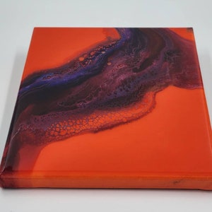 Puede incluir: Pintura abstracta sobre lienzo con un fondo naranja brillante y un dise&ntilde;o de remolino de color morado oscuro y negro.